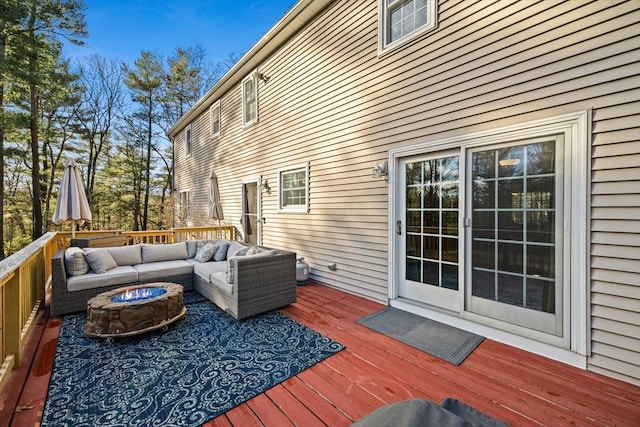 wooden terrace with an outdoor living space with a fire pit