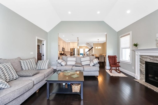 13 Birkdale Ln Unit 13, Hopkinton, MA 01748 - living room with baseboards, a chandelier, dark wood-style floors, lofted ceiling, and a fireplace