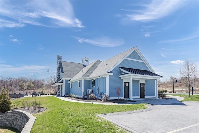 13 Birkdale Ln Unit 13, Hopkinton, MA 01748 - back of property featuring a yard, a standing seam roof, a chimney, metal roof, and a shingled roof