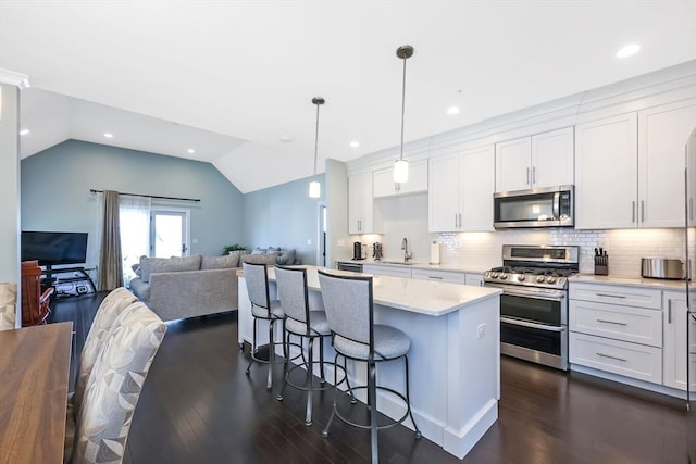 13 Birkdale Ln Unit 13, Hopkinton, MA 01748 - kitchen with stainless steel appliances, a sink, dark wood-style floors, white cabinets, and vaulted ceiling