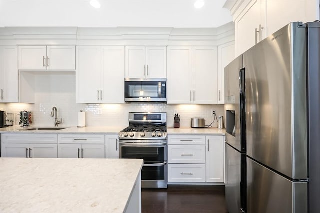13 Birkdale Ln Unit 13, Hopkinton, MA 01748 - kitchen featuring appliances with stainless steel finishes, a sink, white cabinets, decorative backsplash, and recessed lighting