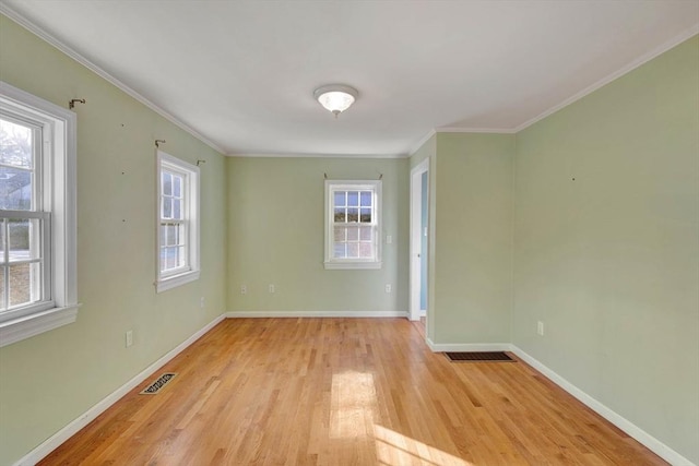 unfurnished room with ornamental molding and light wood-type flooring