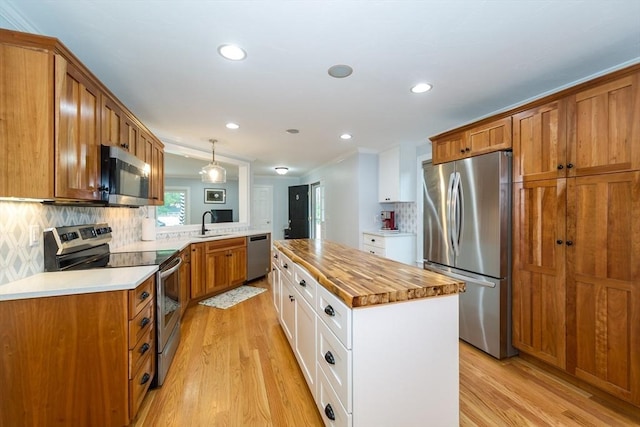 5 Lake Boon Dr, Hudson, MA 01749 - kitchen with appliances with stainless steel finishes, wood counters, light wood-type flooring, crown molding, and a center island