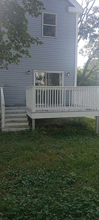 back of house featuring a yard and a wooden deck