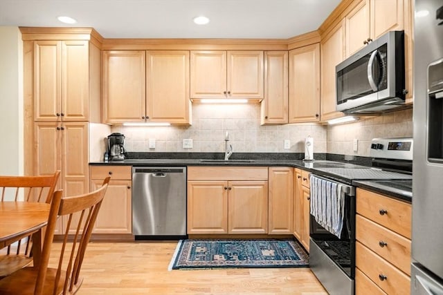 kitchen featuring light brown cabinets, stainless steel appliances, and a sink