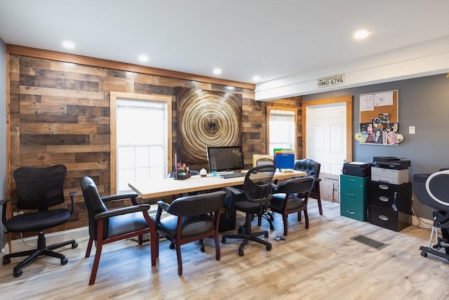 office with a wealth of natural light, wooden walls, and light wood-type flooring