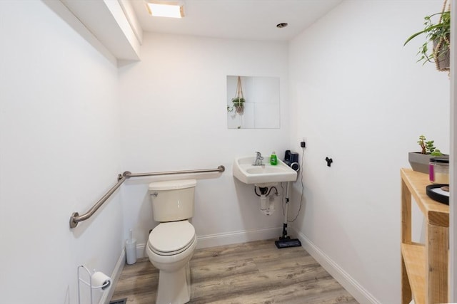 bathroom featuring hardwood / wood-style flooring and toilet