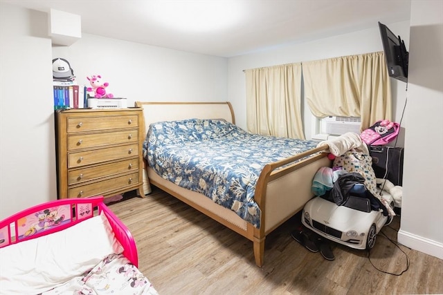 bedroom with cooling unit and light wood-type flooring