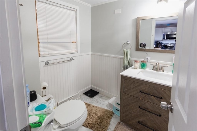 bathroom featuring vanity, crown molding, and toilet