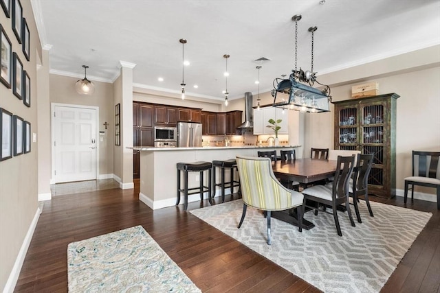 dining space featuring dark wood-style floors, crown molding, and baseboards