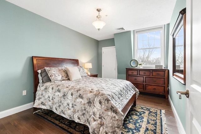 bedroom with baseboards, visible vents, and dark wood-style flooring