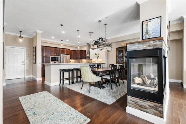 dining area with ornamental molding, dark wood finished floors, and baseboards