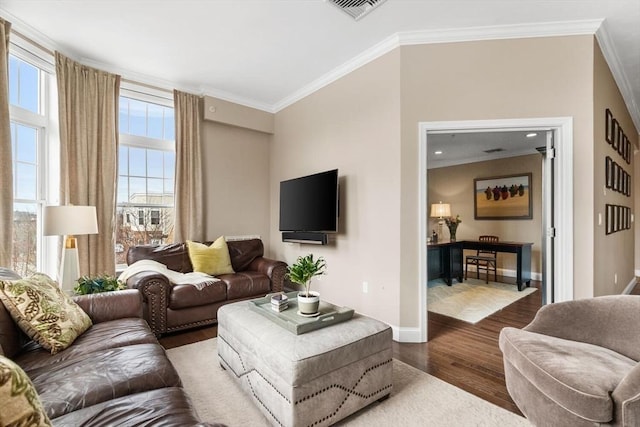 living room featuring baseboards, visible vents, ornamental molding, and wood finished floors