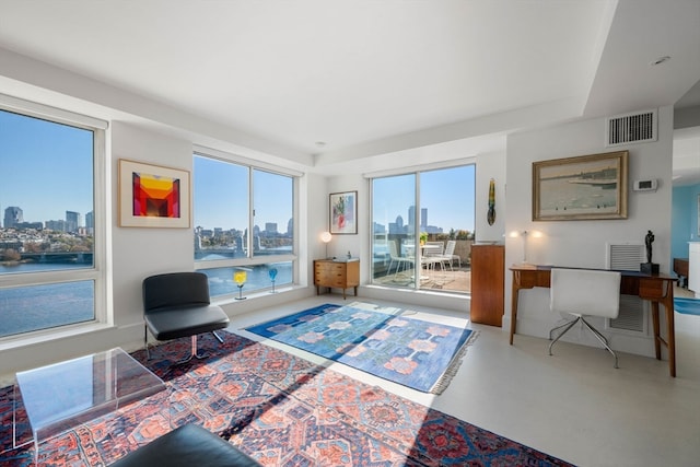 living area featuring a water view and concrete floors