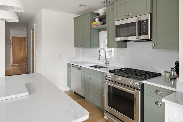 414 Sumner St Unit 1, Boston, MA 02128 - kitchen with green cabinets, appliances with stainless steel finishes, a sink, tasteful backsplash, and light wood-style flooring