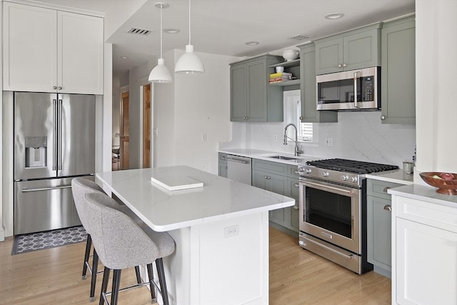 414 Sumner St Unit 1, Boston, MA 02128 - kitchen with appliances with stainless steel finishes, a sink, light wood-style flooring, light stone counters, and recessed lighting