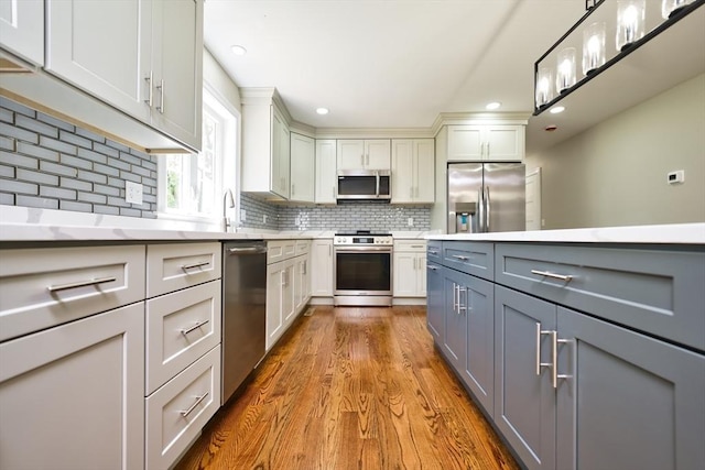 526 Old Warren Rd, Swansea, MA 02777 - kitchen featuring stainless steel appliances, gray cabinetry, light countertops, wood finished floors, and tasteful backsplash