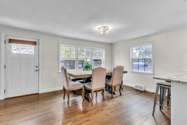 dining area with crown molding and hardwood / wood-style floors