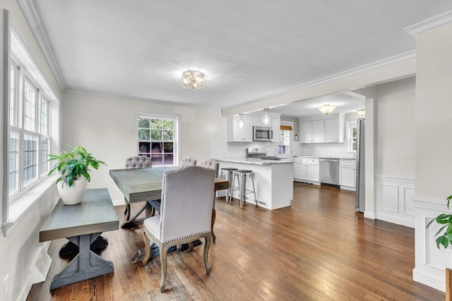 dining area featuring ornamental molding and dark wood-type flooring