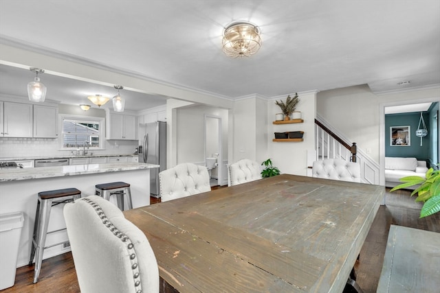 dining area with ornamental molding, dark hardwood / wood-style floors, and sink