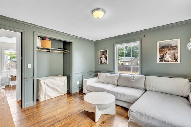 living room with wood-type flooring and ornamental molding