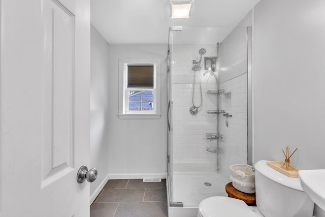 bathroom featuring toilet, tile patterned floors, and an enclosed shower