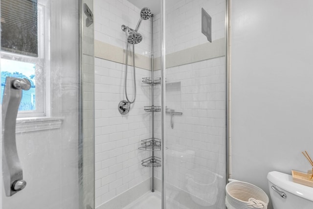 bathroom featuring walk in shower and toilet