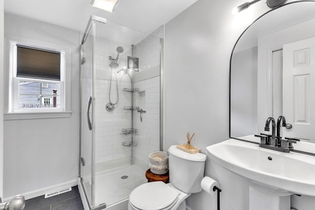 bathroom with sink, tile patterned flooring, toilet, and an enclosed shower