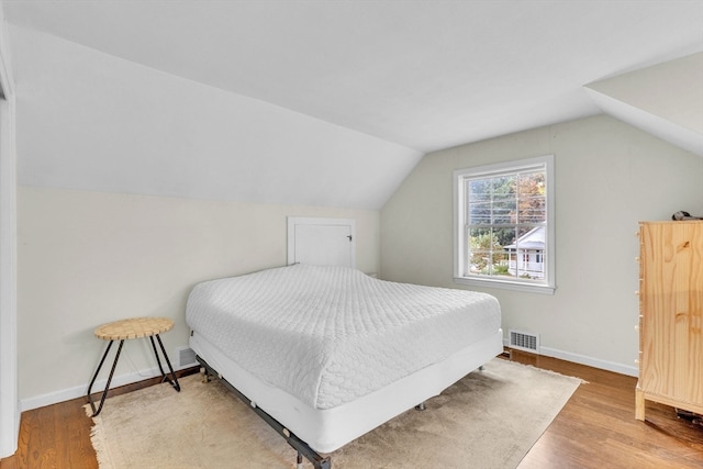 bedroom featuring hardwood / wood-style flooring and vaulted ceiling