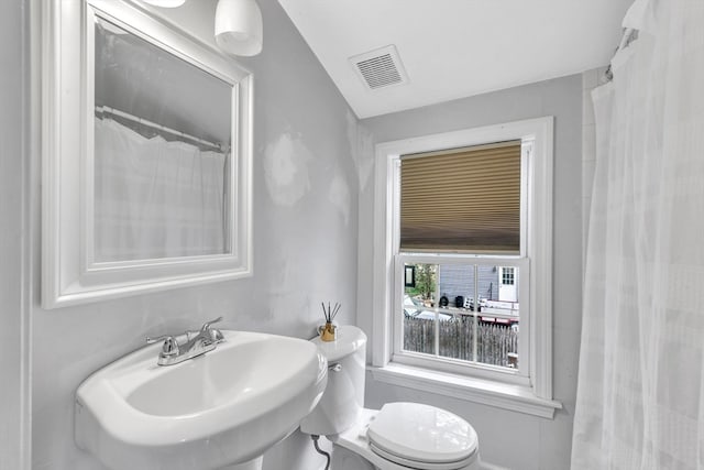 bathroom with a shower with shower curtain, sink, and toilet