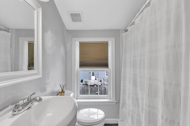 bathroom featuring curtained shower, toilet, and sink