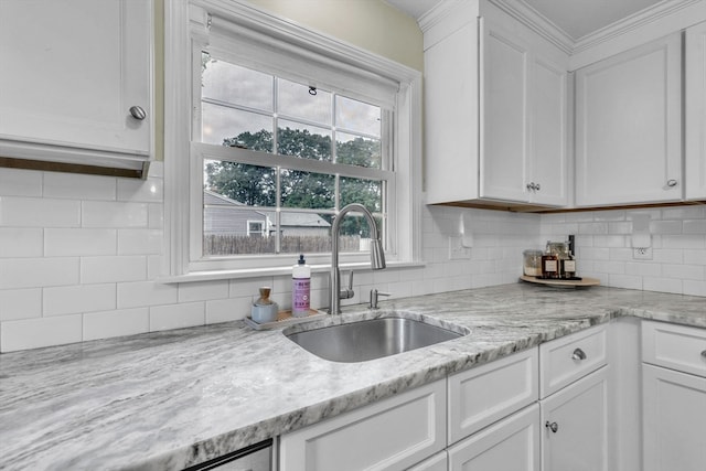 kitchen featuring backsplash, white cabinetry, sink, and light stone counters