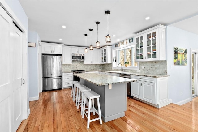 kitchen featuring a sink, white cabinets, tasteful backsplash, and stainless steel appliances