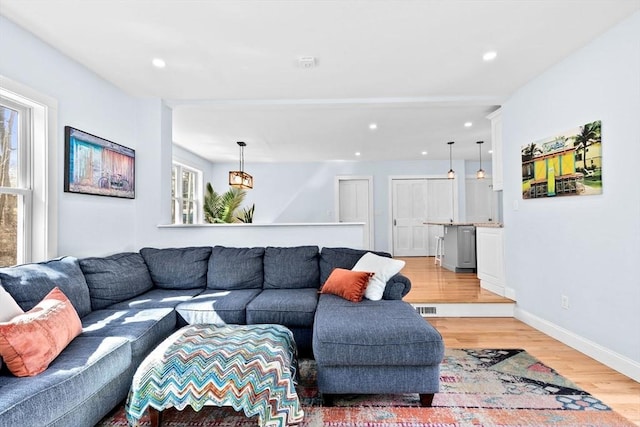 living room featuring light wood-style floors, recessed lighting, and a wealth of natural light