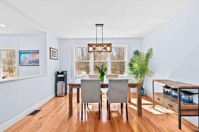 dining area featuring baseboards, light wood-type flooring, and visible vents