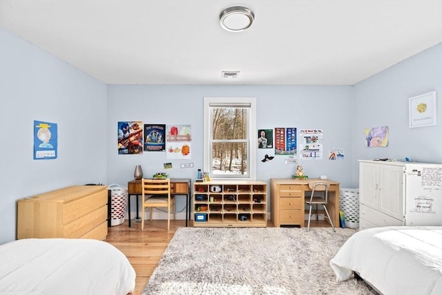 bedroom featuring visible vents and wood finished floors