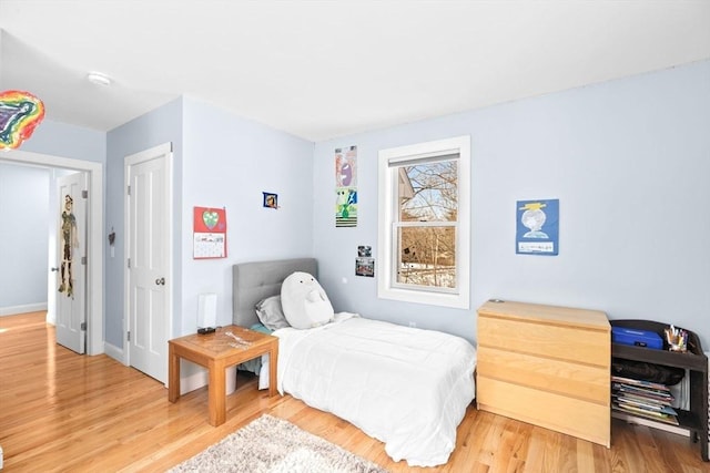 bedroom featuring baseboards and light wood finished floors