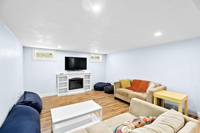 living room with baseboards, light wood finished floors, and a healthy amount of sunlight