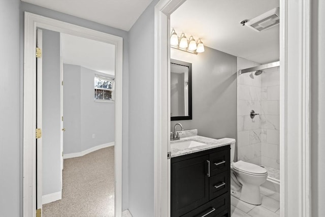 bathroom featuring vanity, tiled shower, and toilet