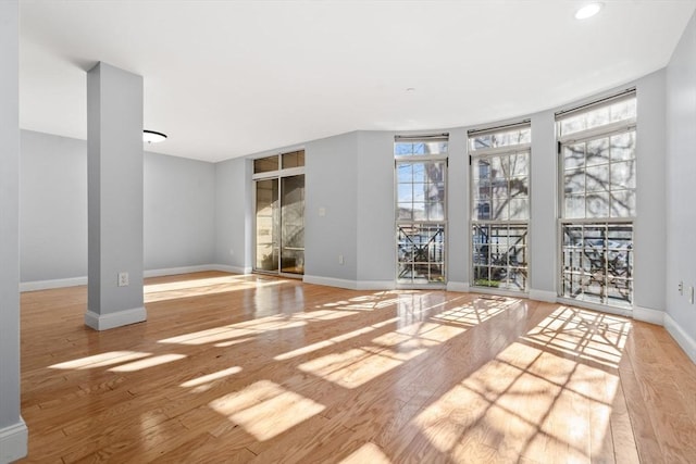 empty room with light hardwood / wood-style flooring and expansive windows