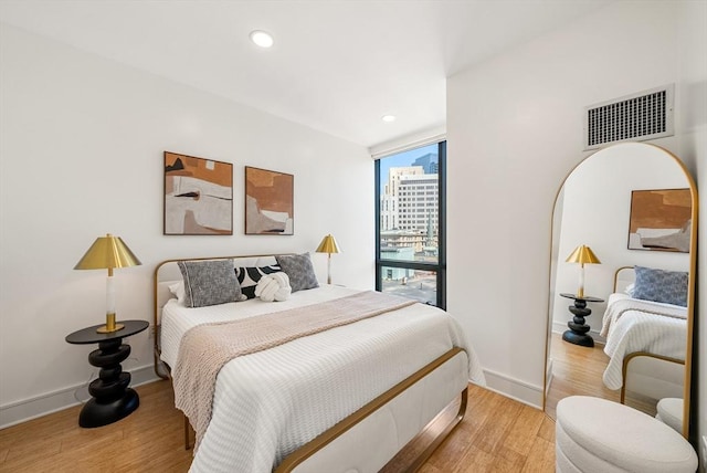 45 Province St Unit 1103, Boston, MA 02108 - bedroom featuring light wood-style flooring, recessed lighting, baseboards, a wall of windows, and arched walkways