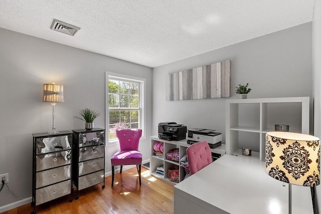 office area with a textured ceiling and wood finished floors