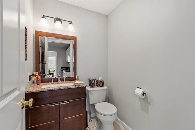 half bathroom with toilet, vanity, tile patterned flooring, and baseboards