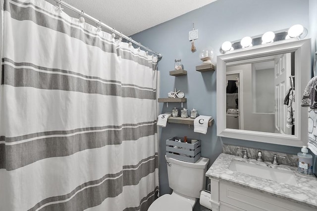 bathroom featuring a textured ceiling, toilet, vanity, washer / dryer, and curtained shower