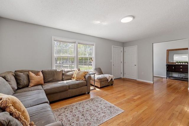 living room with light wood-style floors and a textured ceiling
