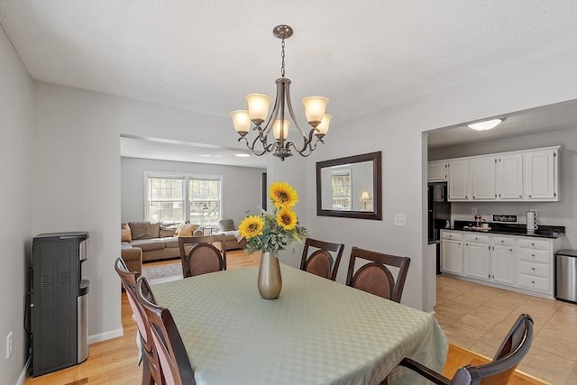 dining area featuring a chandelier and baseboards