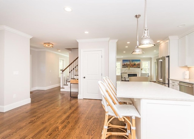 kitchen featuring stainless steel appliances, white cabinetry, recessed lighting, a fireplace, and light countertops