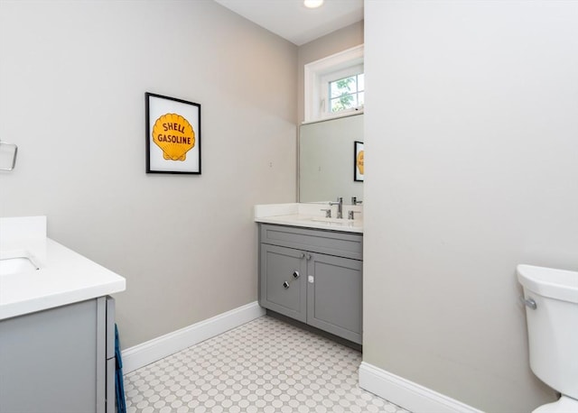 bathroom featuring vanity, baseboards, and toilet