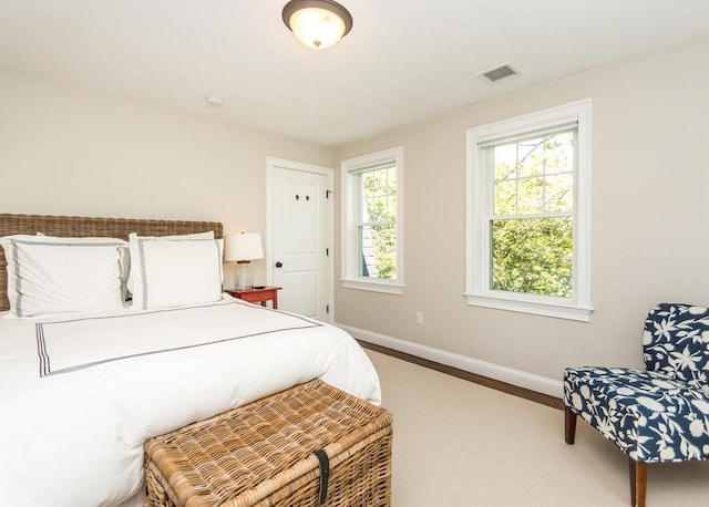 bedroom featuring baseboards, multiple windows, and carpet