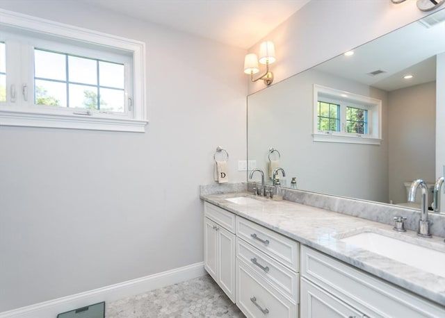 full bathroom with baseboards, double vanity, and recessed lighting